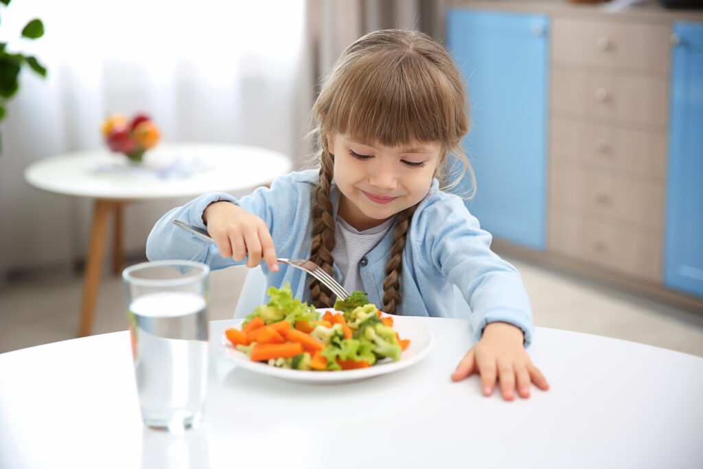 Enfant mange des légumes