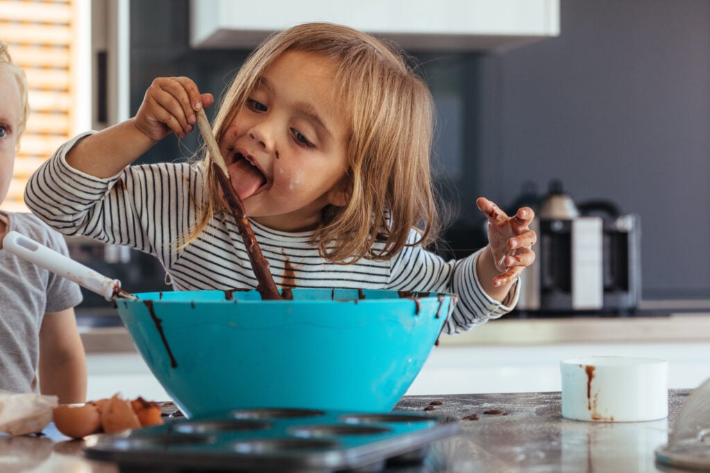 Petite fille goûtant du chocolat 