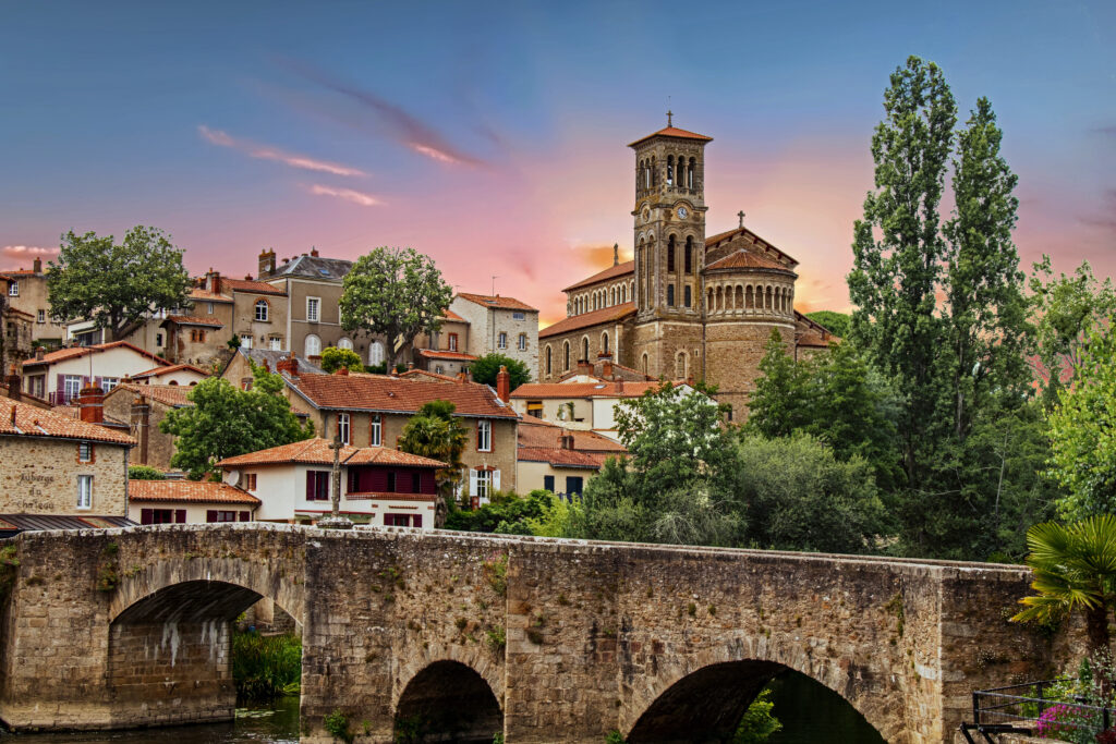 Église Notre-Dame et Pont de la Vallée sous soleil couchant