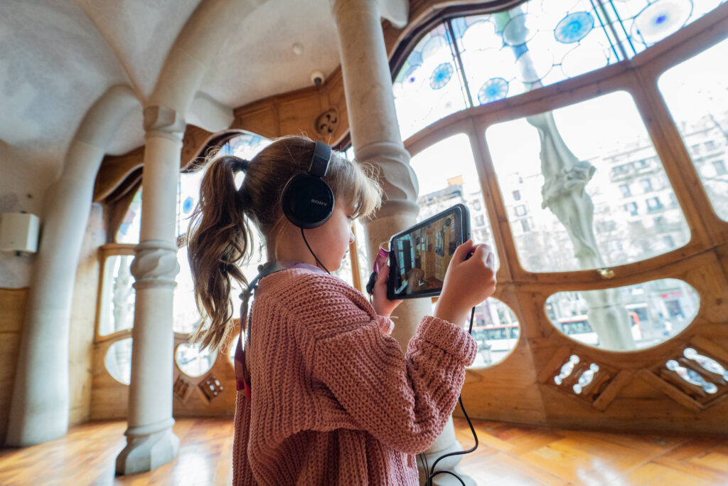 Petite Fille visitant la Casa Batllo avec tablette de réalité augmentée